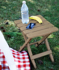 Portable Folding Outdoor Side Table for Indoor and Outdoor Use Weatherproof and Rustproof Durable Plastic Lightweight 2.9 Lb Table holding bottle and banana on grass