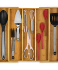 Expandable Bamboo Kitchen Drawer Organizer For Utensils And Flatware, 3 To 5 Slots, filled with kitchen tools.
