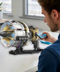 Man controlling Jet Turbofan Engine Model Kit with app, displaying realistic motor, lighting effects, 564 plus pieces.