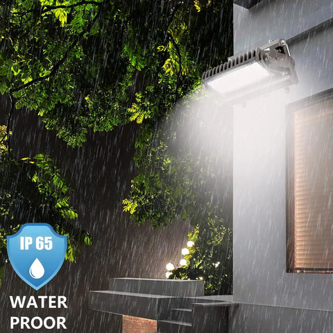 Beefy 80W Rotatable LED Wall Pack Light with 5000K cool white illuminating building exterior during rain, IP65 waterproof