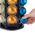 Hand accessing VertuoLine Coffee Pod Carousel Holder With 360 Degree Rotation And Extra Top Shelf Holds 80 Plus Nespresso Vertuo Pods