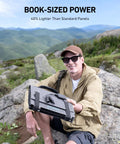 Man holding Solix C200X Portable Power Station with 60W Solar Panel in a mountain setting