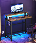Small Computer Desk With Charging Station And LED Lights, Gaming Desk With Monitor Stand, in Rustic Brown with chair