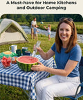 Smiling woman using Watermelon Cutter With Retractable Fork 2 In 1 Stainless Steel Fruit Slicer at a picnic table outdoors.