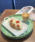 Next Level 12.5 Inch Wooden Lazy Susan With Mother Of Pearl Inlay serving a croissant with strawberries and coffee.