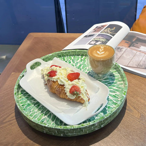 Next Level 12.5 Inch Wooden Lazy Susan With Mother Of Pearl Inlay serving a croissant with strawberries and coffee.