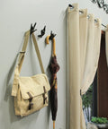 Set Of 3 Hand Gesture Wall Hooks holding a beige bag and umbrella, rustic cast iron decor for entryway, 4 inch design.