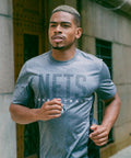 Man jogging in Officially Licensed NBA San Antonio Spurs Tee For Men Women Heather Charcoal Super Soft Supreme Unisex Comfort Fit
