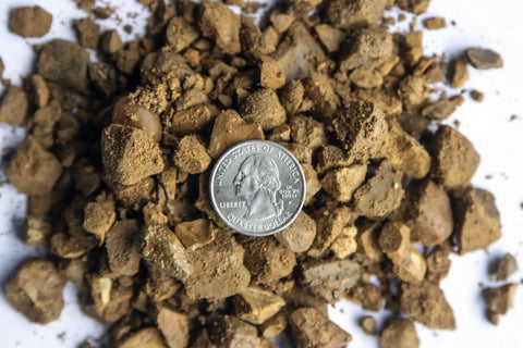 Decomposed Granite For Pathways And Patios, 40 lb bag shown with US quarter for scale, compactable DG gravel with multicolor tones.