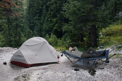 Person relaxing on Portable Foldable Metal Framed Hammock With Cup Holder And Built In Storage Pocket And Quick Fold System For Camping
