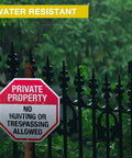 Tough As Nails 6 Pack 12 Inch Rustproof Aluminum Weather Resistant No Hunting Or Trespassing Signs positioned on a wooden post.