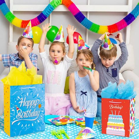 Children celebrating with Birthday Gift Bag Set With Handle And Tissue Paper, 12 Pack Assorted Sizes And Designs visible on table.