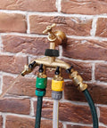 4 Way Heavy Duty Brass Garden Hose Splitter For 3/4 Inch Hoses, No Nonsense Water Faucet Splitter With 4 Valves, Rubber Washers And Teflon Tape, Arthritis Friendly Top Connection, Built Tough Yard Hose Connector For Quick Setup installed on brick wall