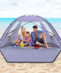 Family sitting under Beach Shade Tent With UPF 50 Plus Sun Protection For 3 To 8 People Portable Family Beach Canopy on sand