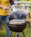 Person grilling with Fish Grill Basket Set With Removable Wooden Handle And 304 Stainless Steel Construction, smoke rising.