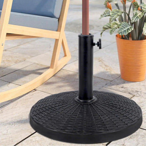 Beefy Heavy Duty 22 Lb Resin Patio Market Umbrella Base Stand in black resin on stone patio with chair and plant nearby