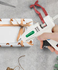 Dope Mini Hot Glue Gun Kit With 30 Glue Sticks used to wrap a gift, showing compact white design and precision nozzle.