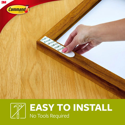 Hand applying Heavyweight Picture Hanging Strips XL 20 Lb 32 Strips 16 Pairs Damage Free Hangers For Picture Frames No Tools Required.