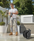 Man using Heavy Duty Pressure Washer Hose Reel 60 Feet By One Quarter Inch Auto Rewind Steel Wall Mount for outdoor cleaning