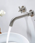 Brushed Nickel Wall Mount Bathroom Faucet With Double Handles Includes Rough In Valve Drip Free Ceramic Disc Cartridge Solid Brass Build Tarnish Resistant No Fuss Install For Modern Sinks mounted above white basin with water flowing