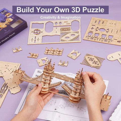 Person assembling Tower Bridge 3D Puzzle Wood Craft Kit with LED Light DIY Construction Model, parts laid out on table.