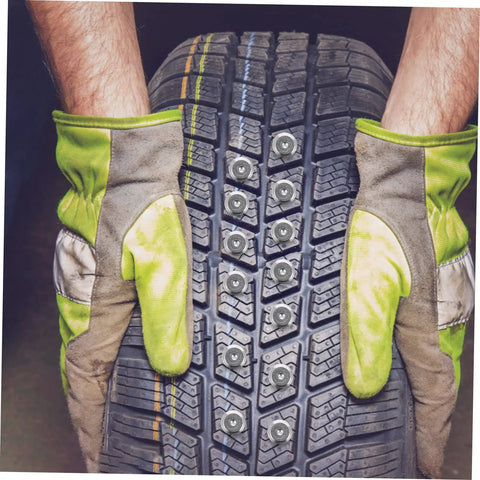 Hands in work gloves holding a winter tire with 200 Piece Winter Tire Studs Heavy Duty Skid Screws Tungsten Snow Spikes installed.