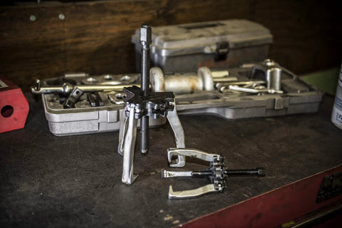 10 Way Slide Hammer Puller Set For Auto Repair With Dual Jaw Options Includes Slide Hammer 2 Yokes Center Bolt Flanges Adapters Legs And Screws For Stubborn Bearings Hubs And Suspension Components on workbench
