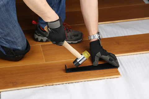 Person installing wooden floor wearing Flat Knee Pads For All Kneeling Jobs, Heavy Duty Knee Cushions with Anti Skid Grip and Adjustable Clips