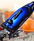 Close-up view of Beast 14 Inch RC Boat For Lakes And Pools with blue hull design and dual propellers, placed on a concrete ledge.