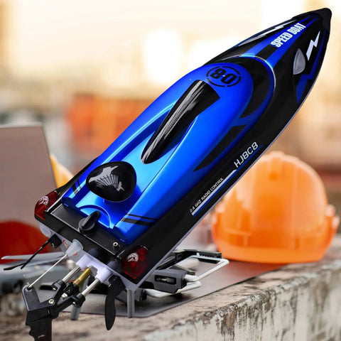 Close-up view of Beast 14 Inch RC Boat For Lakes And Pools with blue hull design and dual propellers, placed on a concrete ledge.