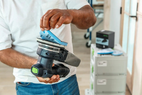 Person attaching Granat Profile Medium Delta Sanding Pad with 1/2 inch foam backing to power tool for contours and corners