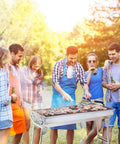 Group of people grilling food outdoors with Portable Stainless Steel Charcoal Grill Folding Outdoor Barbecue Kit for family fun