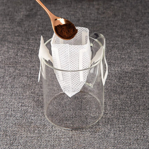 Go To Portable Coffee Filter Bags With Hanging Ear Design positioned over a glass cup, ready for single serve coffee preparation