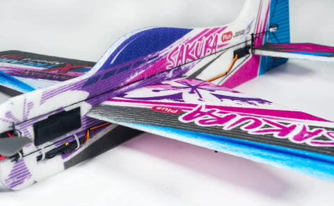 Close-up of Dope Foam RC Plane Kit With 23 Inch Wingspan Sakura Plus EPP Airplane, showing colorful design and electronics setup.