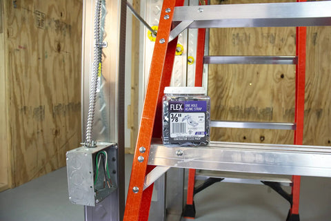 Box of 3/8 In Flex 90 Degree Connector For FMC Metal Clad And Armored Cable next to a steel outlet box and ladder