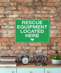 Green aluminum rescue equipment sign on brick wall above table with decor items