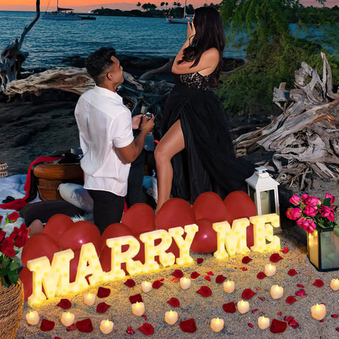 Romantic beach proposal scene with Marry Me Light Up Letters Proposal Kit With 7 Letter Signs 24 LED Tea Lights and balloons.