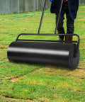 Man using Heavy Duty Steel Lawn Roller 17 Gallon Push Pull Sod Roller Water And Sand Filled 36 By 12 Inch For Lawn Leveling And Seeding