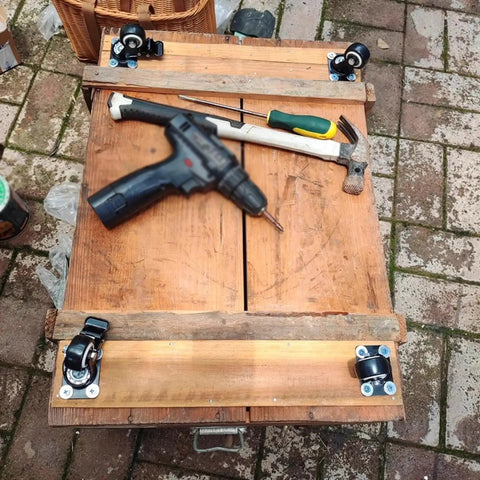 Set Of 4 Heavy Duty Swivel Caster Wheels With Secure Brakes attached to a wooden workbench with tools.