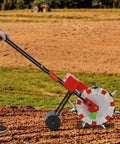 Person using 7 Nozzles Manual Seeder For Easy Hand Push Planting Garden Seeder With 1 To 2 Seeds Per Output Durable Iron And Plastic