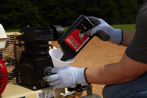 User pouring oil into the Honda engine of the 135 Psi 5.5 Hp Gas Powered Air Compressor for maintenance.