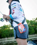 Woman fishing with Waterproof Survival Kit In A Rugged Bag With Emergency Thermal Blanket, Fishing And Sewing Kits, Compass.