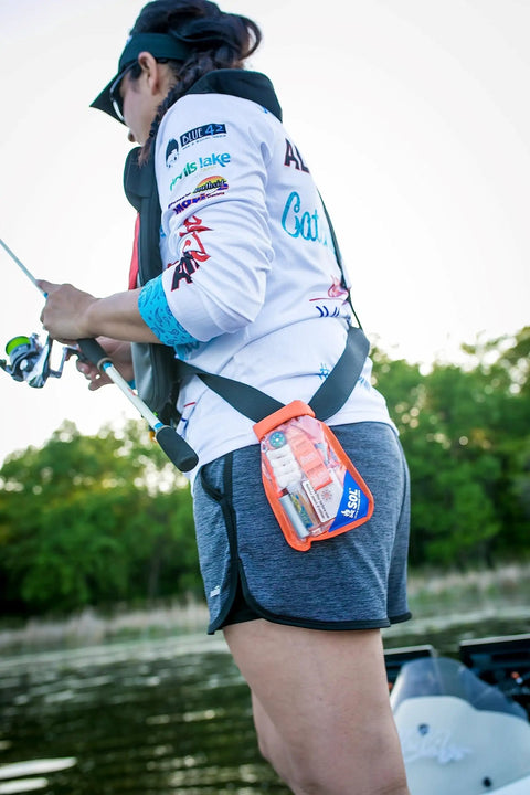 Woman fishing with Waterproof Survival Kit In A Rugged Bag With Emergency Thermal Blanket, Fishing And Sewing Kits, Compass.