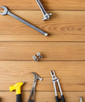Pair M Two Point Five By Zero Point Four Five By Seven Pro Grade Miniature Screws on wooden surface with tools