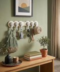 Compact Heavy Duty Six Hook Adhesive Wall Rack With Smooth 180 Degree Swivel for keys and towels on a green wall.
