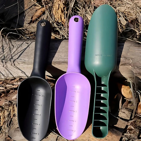 Three garden tools, including a black thickened plastic garden soil scoop with ergonomic handle, on wooden surface