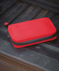 Ultra Slick Compact Semi Rigid Utility Organizer Case Built Tough With Weather Resistant Shell For Quick Tool Kit First Aid Electronics And Sweet Travel Gear Stash In Bold Red lying on a truck bed.