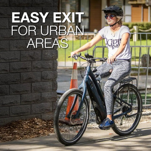 Person biking in urban area next to wall, wearing helmet, demonstrating easy urban exit and entry with comfortable ride.