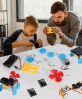 Boy and man assembling 4 In 1 Solar Power And Electric Motor STEM Kit For Kids Beginners With Solar Car on table