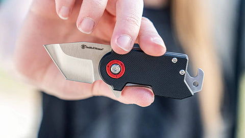 Person holding Compact 2.5 Inch Folding Keychain Knife With 1.75 Inch Modified Tanto Blade And G10 Handle for outdoor use.